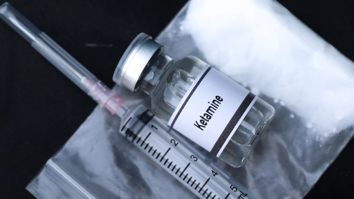 Syringe next to a vial labeled ketamine.