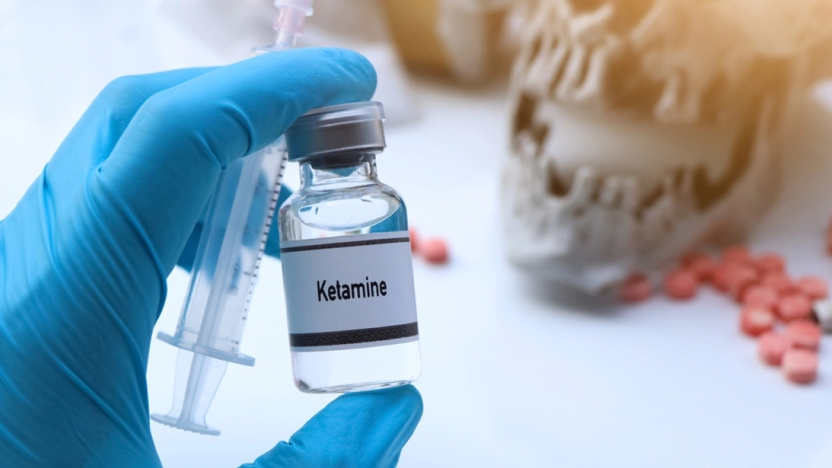 Doctor holding a clear bottle labeled Ketamine