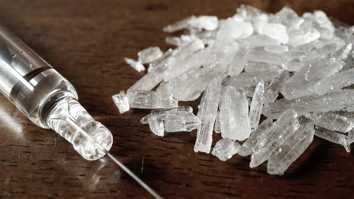 Close-up of methamphetamine crystals on a dark background.