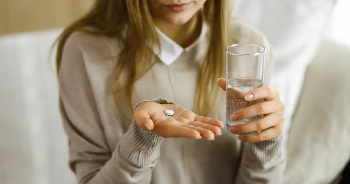 A person’s hand reaching for a pill bottle with the label ‘Suboxone’ symbolizes the potential treatment of benzos addiction.